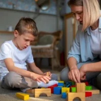 mother-playing-with-her-autistic-son-using-toys
